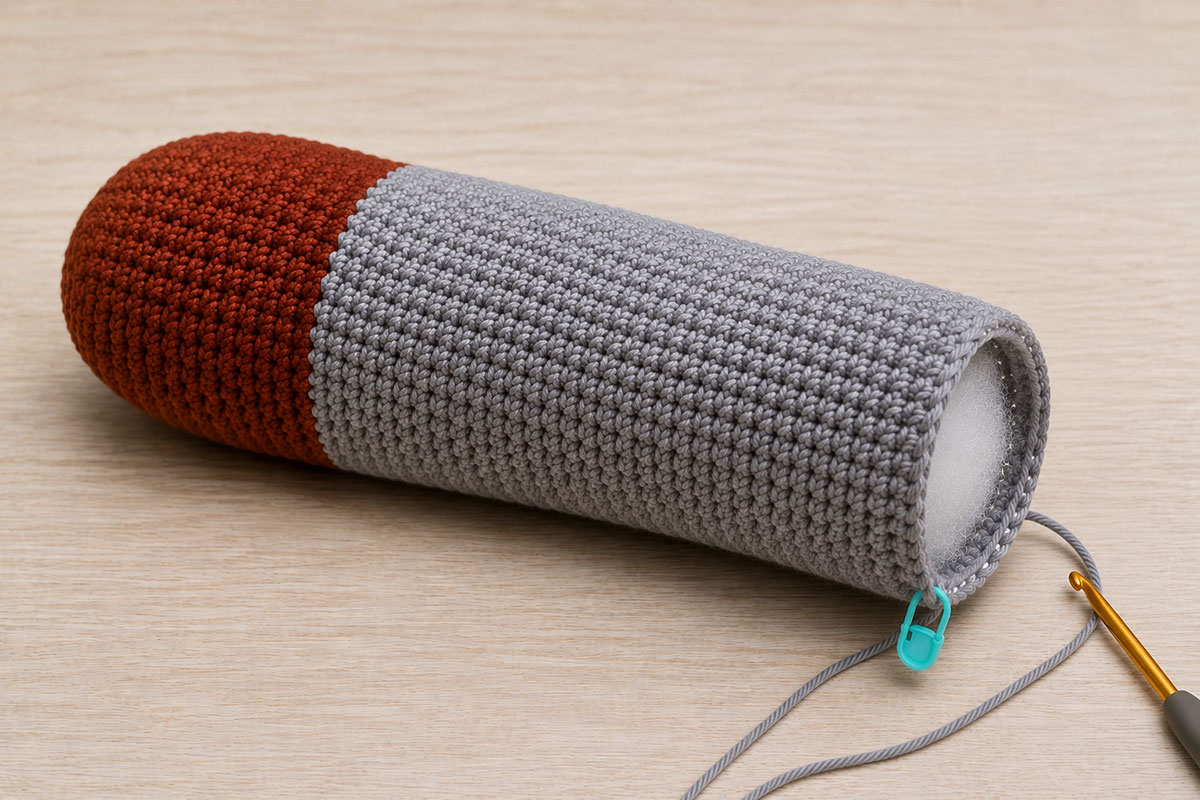 Crochet mallard body in progress showing the chestnut breast and long gray body before the black tail section is added