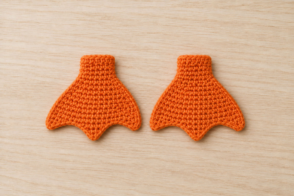 Two matching flat orange crochet mallard feet with short ankle pieces and three shallow webbed toe points