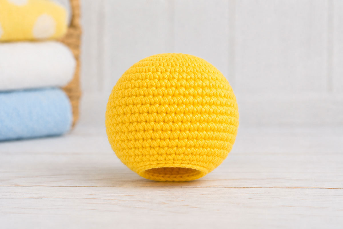 Round yellow crochet duck head stuffed and left open at the twelve-stitch neck