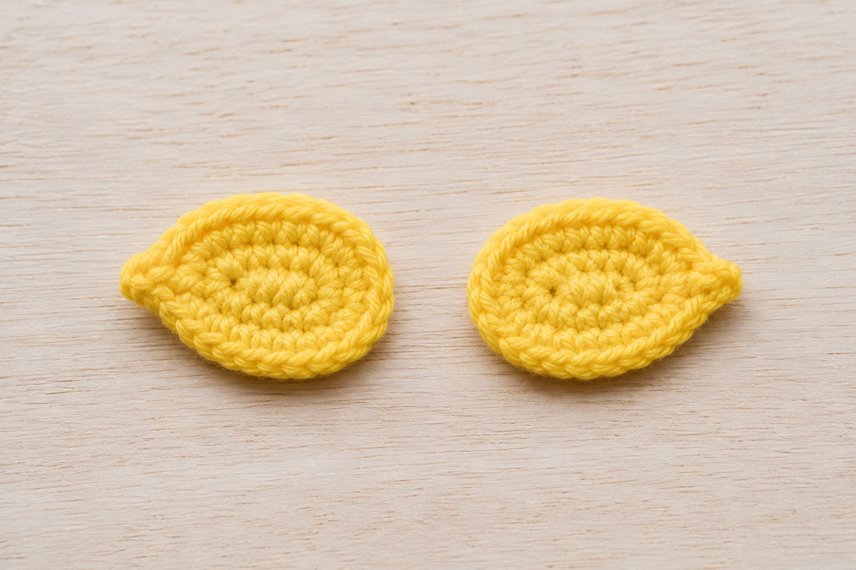 Pair of matching yellow crochet oval wings pinched slightly at the front ends