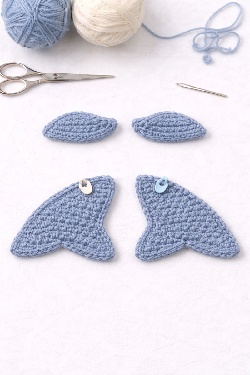 Crochet whale fins and tail pieces prepared for assembly