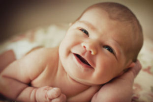 9 day old baby girl smiling portrait