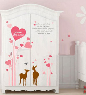 Deer stickers on an armoire in a baby girl nursery room