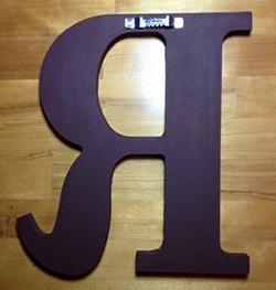 Back of a custom made hand painted wooden wall letter with hanger