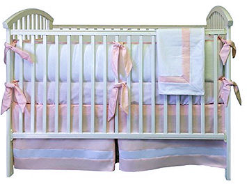 Tailored pink and white bedding set for a baby girl with a crib skirt made with box pleats