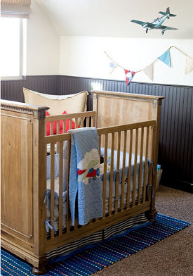 Jet airplane baby nursery theme with vintage decor and navy blue wainscoting and applique crib quilt
