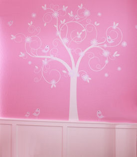 Large vinyl tree wall decal on the walls of a pink baby girl nursery with flowers and birds