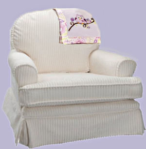 Comfortable chair for a baby nursery upholstered in soft cream color chenille fabric