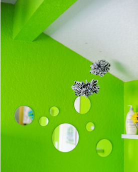 Lime green baby nursery walls with an arrangement of mirror decorations