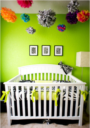 Custom zebra print baby crib bedding set with personalized pillows in a nursery with lime green wall paint color