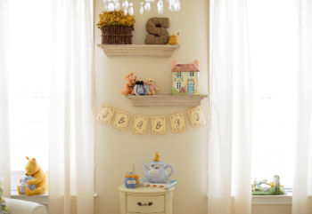 Vintage Winnie the Pooh collectibles on display in the baby's nursery