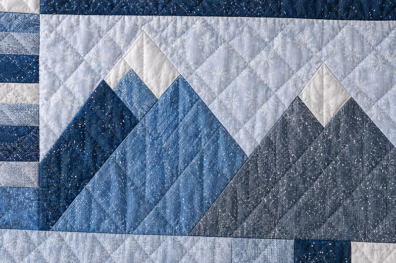 Closeup fabric detail of mountain patchwork crib quilt pattern