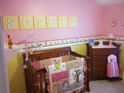 The yellow wall letters spell out Sophie's name.  The pink wall paint color of her Winnie the Pooh theme nursery is the perfect background for them.