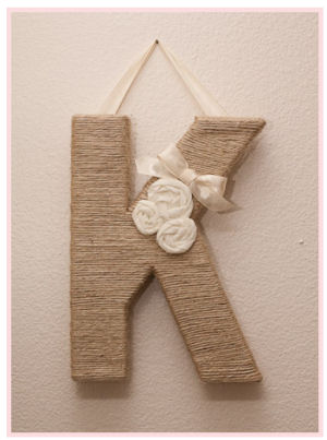 Baby girl nursery wall initial letter K wrapped in twine decorated with fabric ivory rosettes