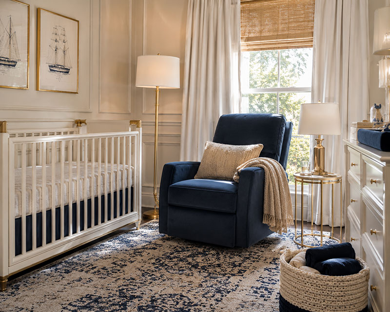 Editorial style nursery recliner placement beside crib with open walking space