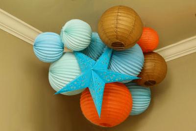 The aqua blue, brown and orange star and orb paper lantern nursery ceiling cluster reflects the color scheme of Baby J's room. 