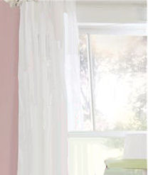 Sheer white curtain panels in a pink baby girl nursery room
