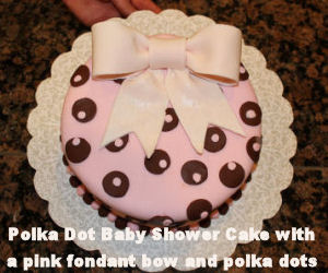 Pink and brown baby shower cake with large fondant bow topper and polka dots for a baby girl