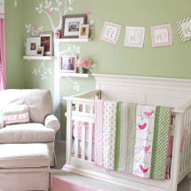 Pink and green baby girl nursery with tree wall decal and photos on shelves