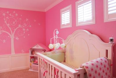 Pink baby girl nursery with striped walls, ruffled fuschia curtains and polka dot sheers.