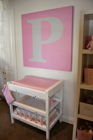 Large pink and white letter P painted wall canvas on a modern baby girl nursery wall