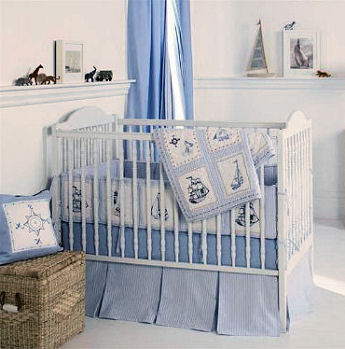 Pirate baby bedding set with crib quilt, bed skirt and bumper pad in a baby blue nursery room