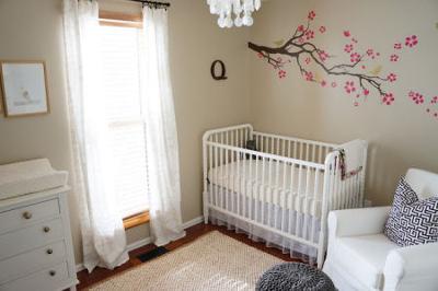 This baby girl's raspberry pink and gray nursery has an elegant and airy atmosphere including golden birds perched on branches and elements that make the room comfortable and cozy.