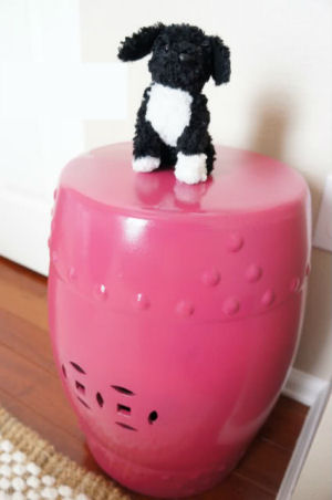 Raspberry pink ceramic garden stool used as decor in a baby girl nursery room