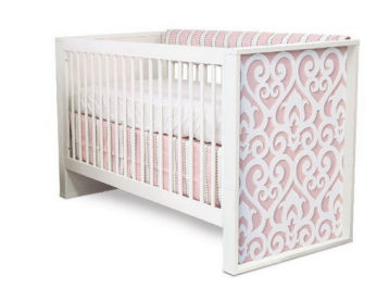 Pink and grey baby girl crib bedding set in an elegant crib with woodworking cut outs details carved