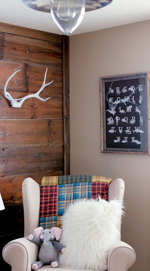 Rustic nursery ideas with reclaimed wood wall deer antlers decor and a comfortable rocking chair
