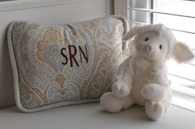 A plush stuffed toy and a personalized monogrammed pillow to match the crib set