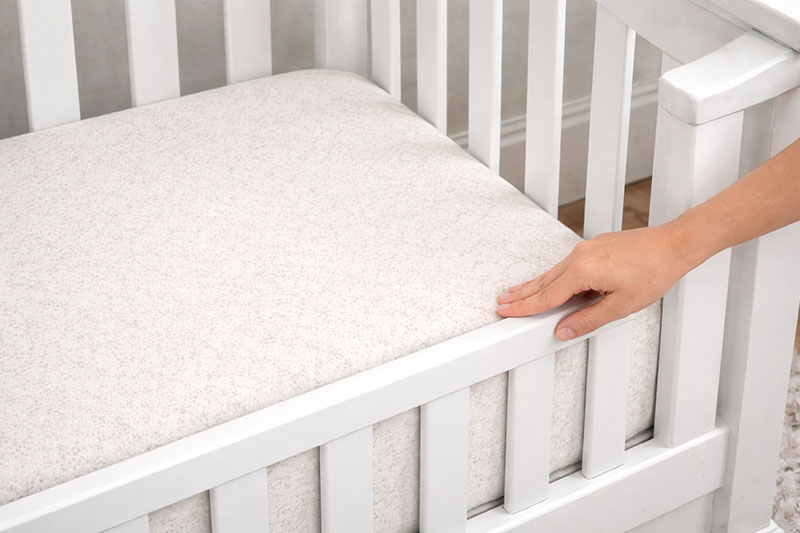 Crib mattress properly fitted inside a Simmons baby crib with no gaps