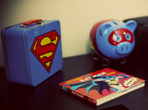 Vintage Superman lunchbox, bank and Batman book are decorations for the baby's nursery