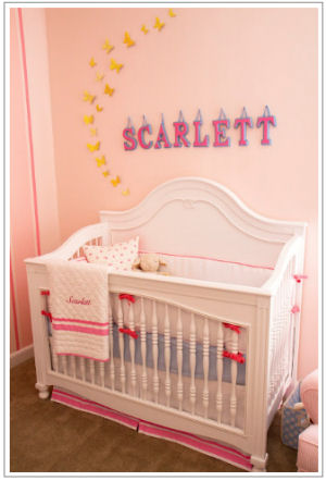 White crib with personalized quilt and Pottery Barn Kids baby bedding set in a vintage girl nursery