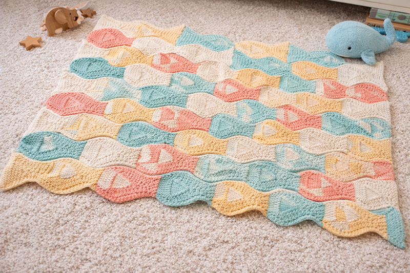 Tessellated fish knitting pattern blanket in soft ocean pastel colors