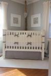 A creamy ivory and light gray crib bedding set in a masculine, baby boy nursery with touches of burlap and woven storage baskets.