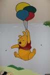 A closeup view of Pooh Bear taking a balloon ride 