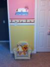 We painted the walls of our baby girl's Winnie the Pooh nursery in pink and yellow paint from Behr and added a white wooden molding as a chair rail to divide the colors.