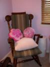 Our baby girl's nursery rocker with brown and pink cushions and throw pillows