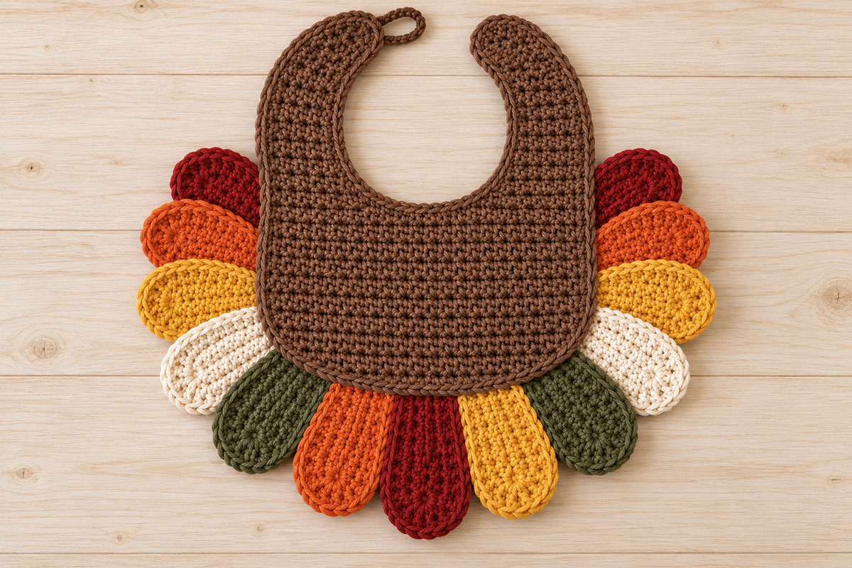 Back of the crochet turkey bib showing the placement and overlapping arrangement of the thirteen autumn colored tail feathers before final assembly