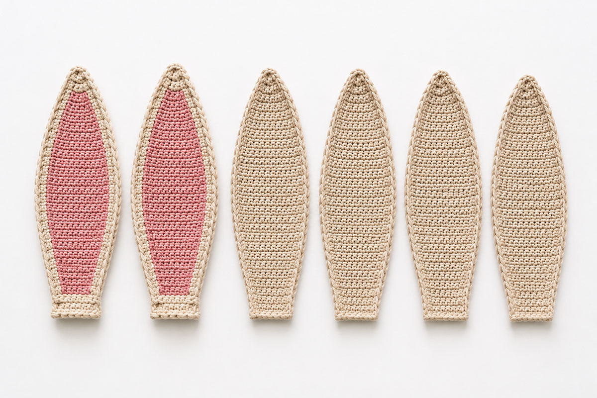 Two upright crochet bunny ears beside four matching flat ear panels showing the doubled ear construction