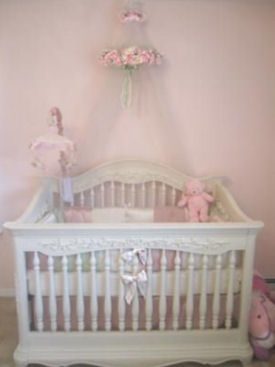 Elegant white baby girl crib with carved wood details and medallions