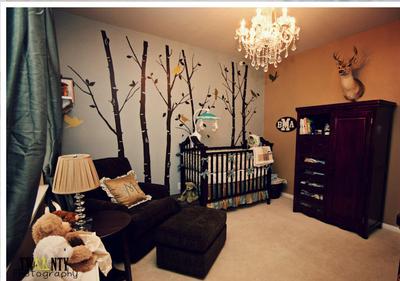 Woodland creatures decorate nursery walls in a baby boy's nursery filled with forest creatures