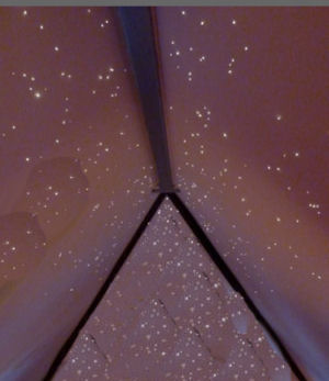 Fiber optic lights twinkle like stars on a sloped ceiling in a baby's nursery