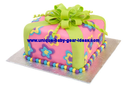 Lime green and purple girl baby shower or birthday party cake with fondant flowers topped with a large bow made of fondant ribbons.