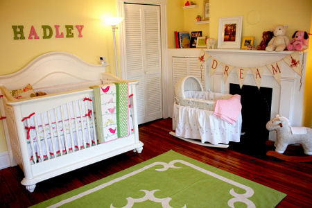 Baby girl bird theme nursery in pink and yellow with painted wall stripes