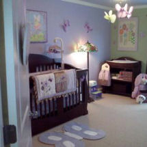 Lavender nursery wall paint with green and brown butterfly baby bedding, area rug and crib mobile