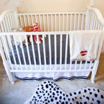 Baby boy neutral nursery with cheetah print area rug