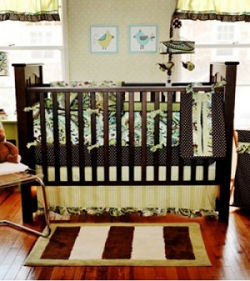 Green and chocolate brown paisley baby crib bedding set in a nature nursery theme with a tree wall mural created with a large decal