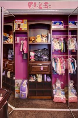 Closet organizer system in a pink princess theme baby nursery closet